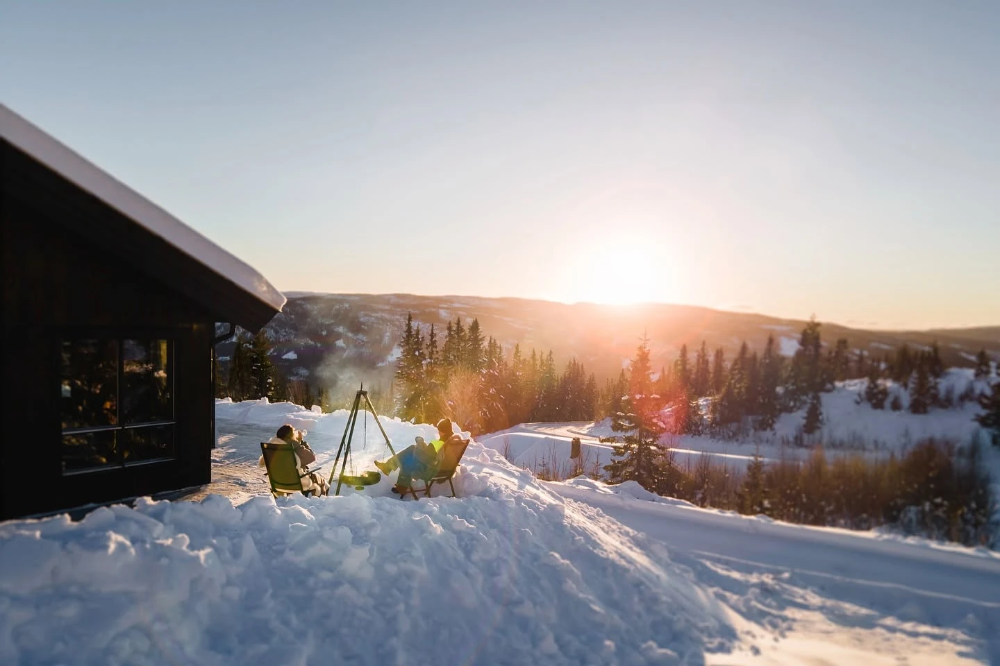Hytta i snøen med sola som går ned over Valdres