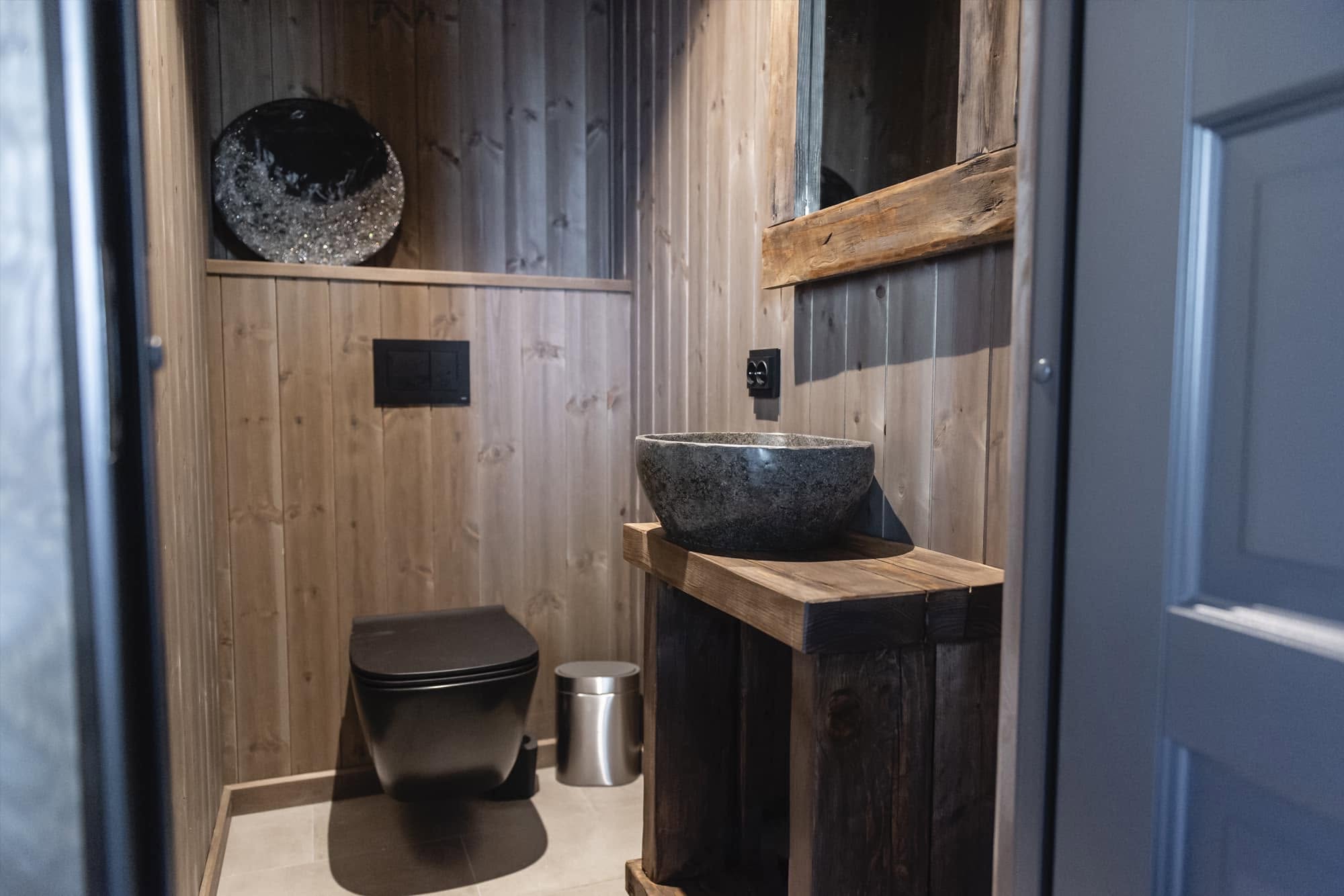 Badet med servant i stein og trepanel