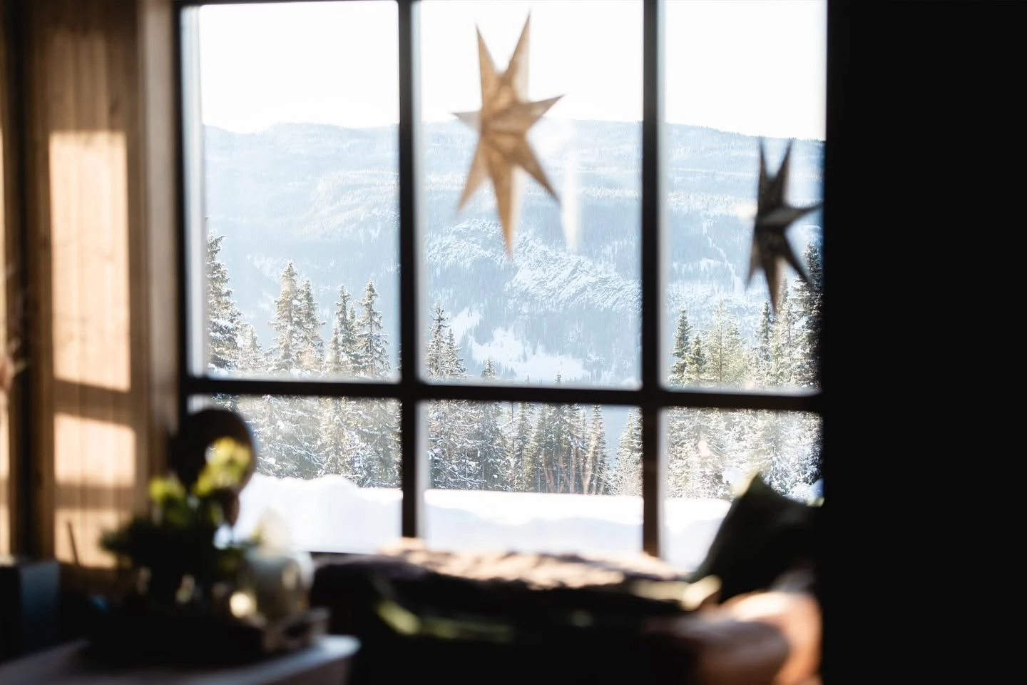 Stua med store vinduer og utsikt mot snødekket skog